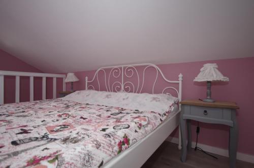 a bedroom with a bed and a table with a lamp at Guest House Romantika Panzio in Gyula