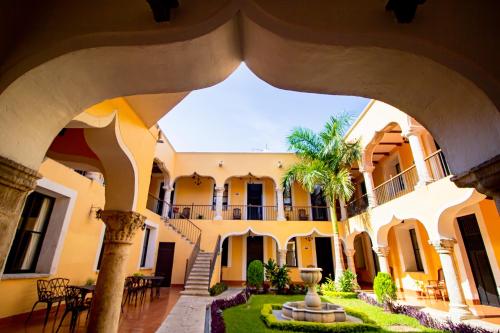 a courtyard of a building with a palm tree at Hotel Montejo in Mérida