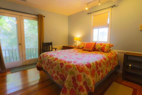 a bedroom with a bed and two windows at Decked Out in Sullivans Island