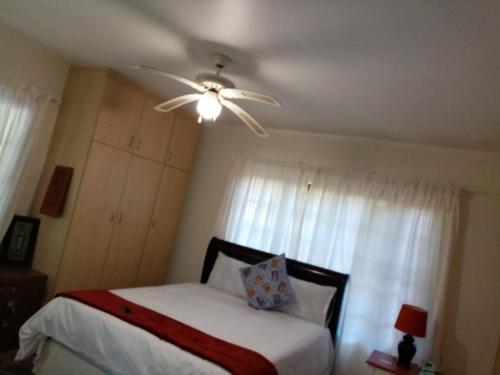 Stesh Margate Holiday House 12 Sleeper في مارغيت: غرفة نوم مع سرير ومروحة سقف