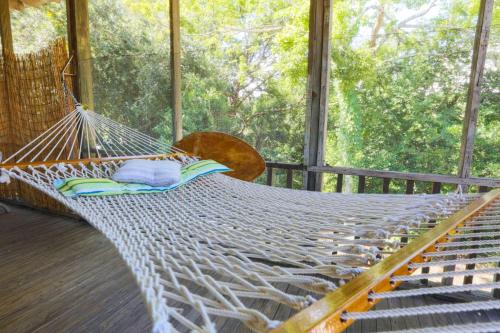 a hammock in a screened in porch with a window at Decked Out in Sullivans Island