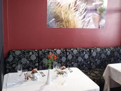 a table with a vase with a flower on it at Hotel Solaris in São Miguel dʼOeste