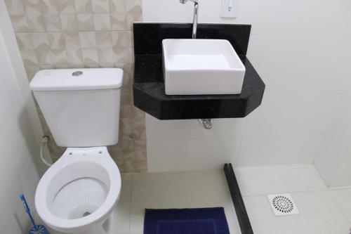un bagno con un water bianco e un lavandino di Ap novo a 90m da praia a Guarapari