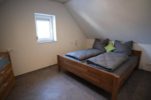 a bedroom with a wooden bed with pillows and a window at Ferienwohnung Koller nähe Playmobil Fun-Park in Cadolzburg
