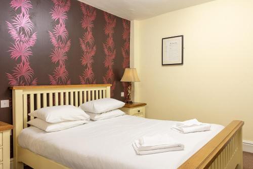 a bedroom with a bed with white towels on it at The New Inn by Roomsbooked in Gloucester