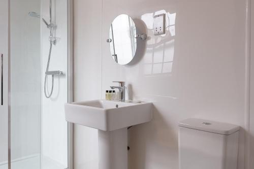 a white bathroom with a sink and a mirror at The New Inn by Roomsbooked in Gloucester