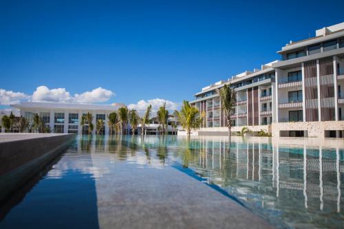 a swimming pool in front of a building at Majestic Elegance Costa Mujeres - All Inclusive in Cancún