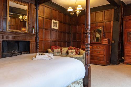a bedroom with a large bed and a fireplace at The New Inn by Roomsbooked in Gloucester