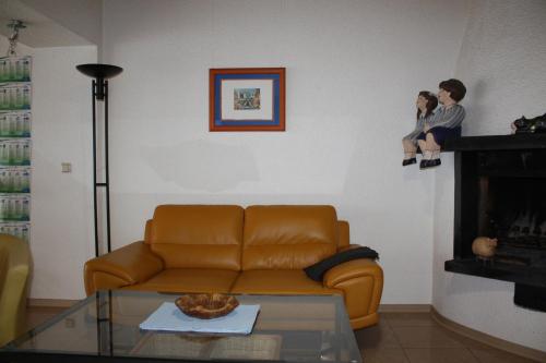 a living room with a couch and a person sitting on a fireplace at Apartment Charlotte in Neunkirchen