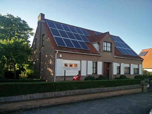 une maison avec des panneaux solaires sur le toit dans l'établissement Villa Monique, à Coxyde