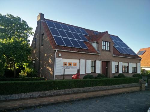 uma casa com painéis solares no telhado em Villa Monique em Koksijde