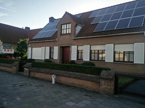 a house with solar panels on top of it at Villa Monique in Koksijde