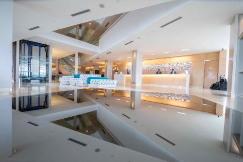 a lobby of a building with white floors and ceilings at The Grand Hotel in Punta del Este