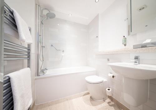 a white bathroom with a toilet and a sink at The White Lion by Innkeeper's Collection in Ambleside