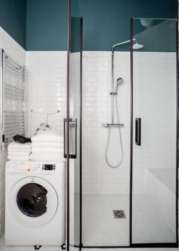 La salle de bains est pourvue d'un lave-linge et d'une douche. dans l'établissement Habitat Parisien - 1BR-1BA - Bourse Montorgueil, à Paris
