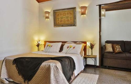 a bedroom with a large bed and a couch at Solar dos Ipês in Serra do Cipo