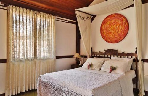 a bedroom with a bed and a large window at Solar dos Ipês in Serra do Cipo