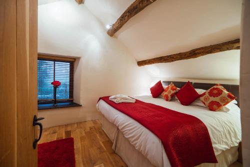 a bedroom with a bed with red pillows and a window at The Lazy Fish in Cockermouth