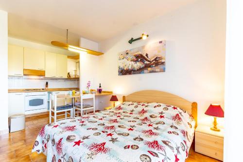 a bedroom with a bed and a kitchen at Apartments Tri Žala in Korčula