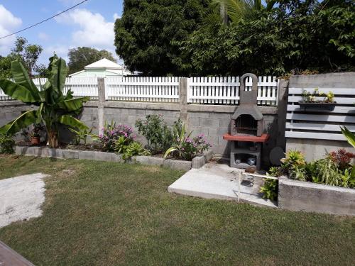 a garden with a grill in a fence at LES MULTIPLIANTS in Le Moule