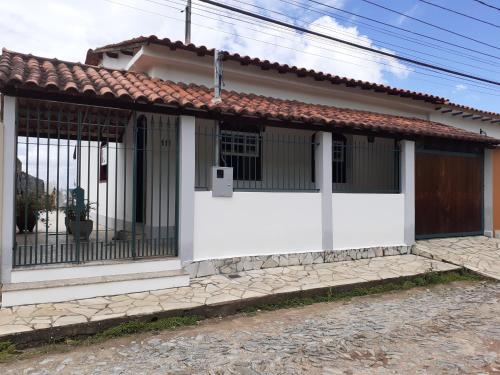 ein kleines weißes Haus mit einem Tor in der Unterkunft Casa do Paulo da Santissima in Tiradentes