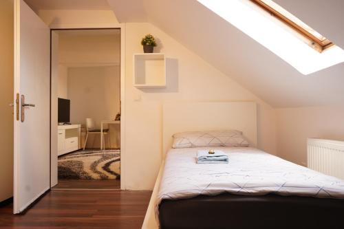 ein Schlafzimmer mit einem Bett im Dachgeschoss in der Unterkunft Vivo Apartments Herne in Herne