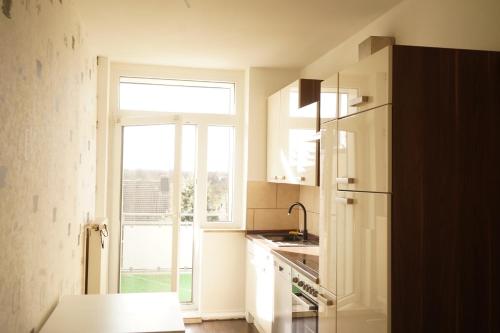 a kitchen with a refrigerator and a window at Vivo Apartments Herne in Herne