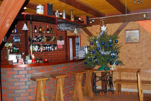 a christmas tree in front of a bar at Zajazd i Restauracja "Myśliwskie Zacisze" in Nikielkowo