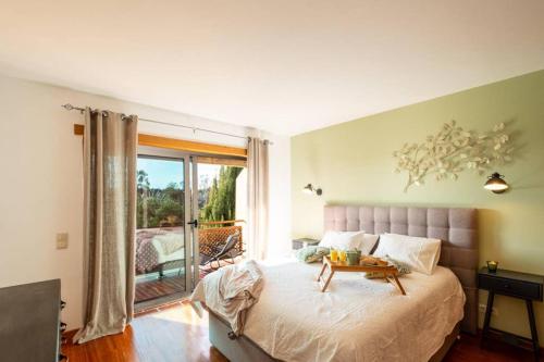 a bedroom with a bed and a large window at Country chic duplex in Algarve in Pêra