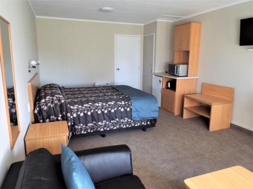 a hotel room with a bed and a couch at Turangi Bridge Motel in Turangi