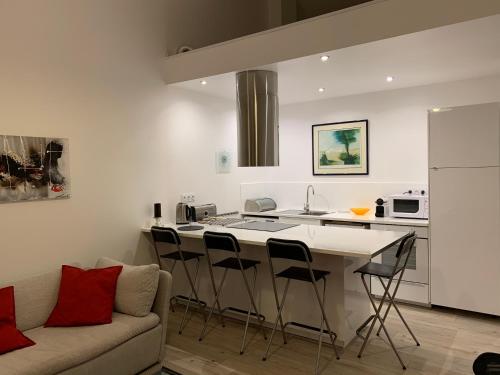 een keuken met een bank en een tafel met stoelen bij Bel Appartement Terrasse 4 Étoiles Intra Muros in Aigues-Mortes