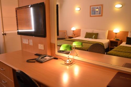 Ένα ή περισσότερα κρεβάτια σε δωμάτιο στο Airport Motel Brisbane