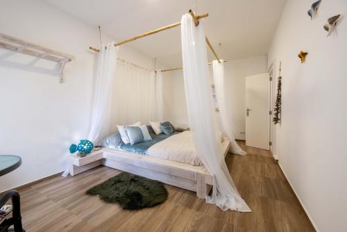a bedroom with a bed with a mosquito net at O Quintal Guesthouse in Carvoeiro
