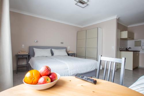 a bedroom with a bowl of fruit on a table at H-Apartments Bismarckstrasse in Trier