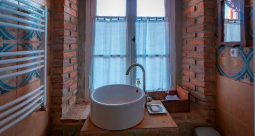 a bathroom with a large white sink and a window at Dzveli Galavani -Old Wall in Tʼelavi