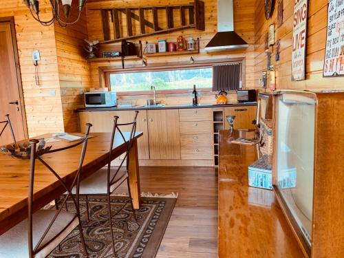 a kitchen with a table and a sink and a refrigerator at Herdade do Moinho Novo in Canha
