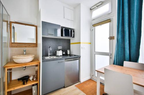 une petite cuisine avec un évier et un comptoir dans l'établissement cosy independant studio proche gare et jardin, à Paris