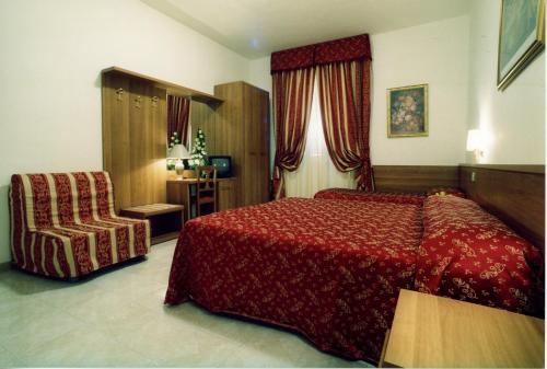ローマにあるホテル マジックの赤いベッドと椅子が備わるホテルルームです。