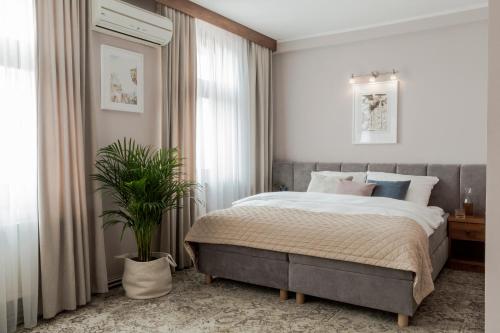 a bedroom with a bed and a potted plant at Hotel Karczma Chełmińska in Chełmno