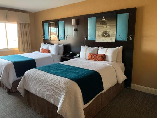 two beds in a hotel room with blue mirrors at The Dylan Hotel at SFO in Millbrae