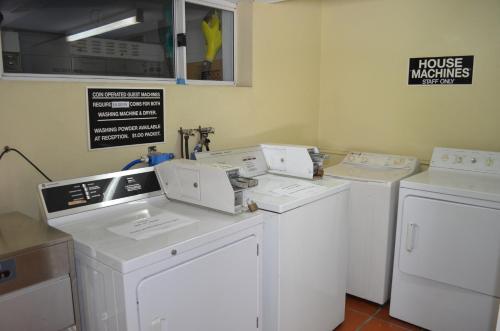 a white kitchen with a white refrigerator and a white sink at Airport Motel Brisbane in Brisbane