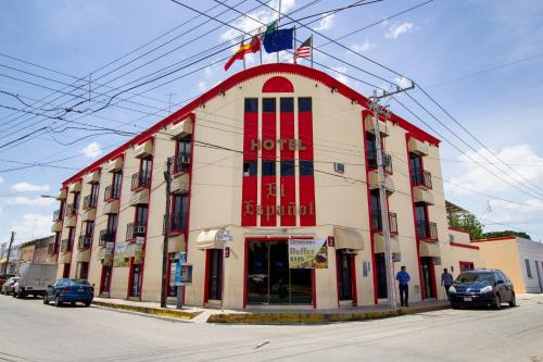 czerwono-biały budynek z flagą na górze w obiekcie Hotel El Español Centro Historico w mieście Mérida
