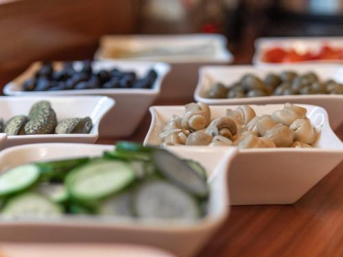 a table topped with bowls of different types of food at Hotel Miodowa in Kraków