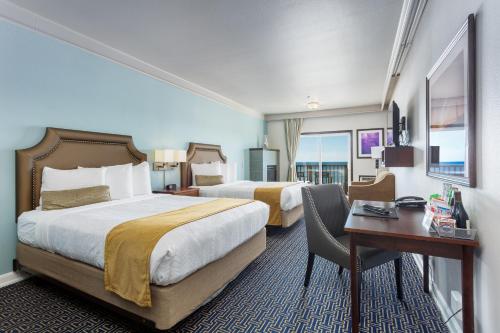 a hotel room with two beds and a desk at Inn at Nye Beach in Newport