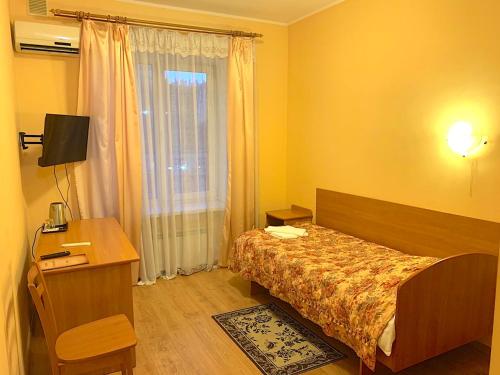 1 dormitorio con cama, escritorio y ventana en Inn on Zhytomyrska en Kiev