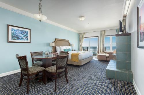 a hotel room with a bed and a table and chairs at Inn at Nye Beach in Newport