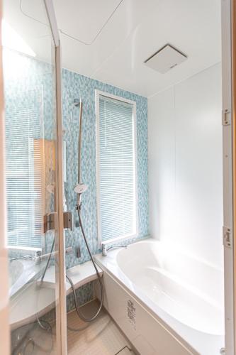 a bathroom with a bath tub and a window at 天弓イン in Kachabaru