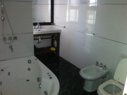 a bathroom with a tub and a toilet and a sink at BRISAS DEL MAR in Santa Teresita