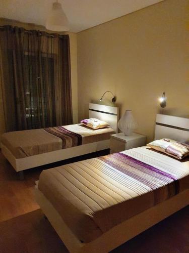 a bedroom with two beds and a window at Apartamento T3 Ponta Delgada in Ponta Delgada