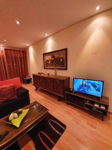 a living room with a couch and a flat screen tv at Apartamento T3 Ponta Delgada in Ponta Delgada